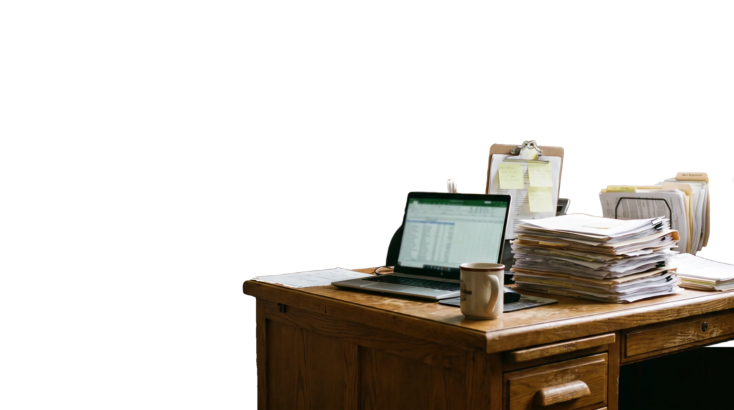 A small business desk buried in invoices, order forms, quotes and a clipboard of notes, beside a laptop showing a spreadsheet.